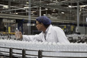 Factory worker examining bottled water