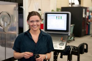 Female CNC Machinist wearing safety glasses