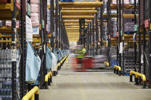 Forklift driving across an aisle in a warehouse, motion blur