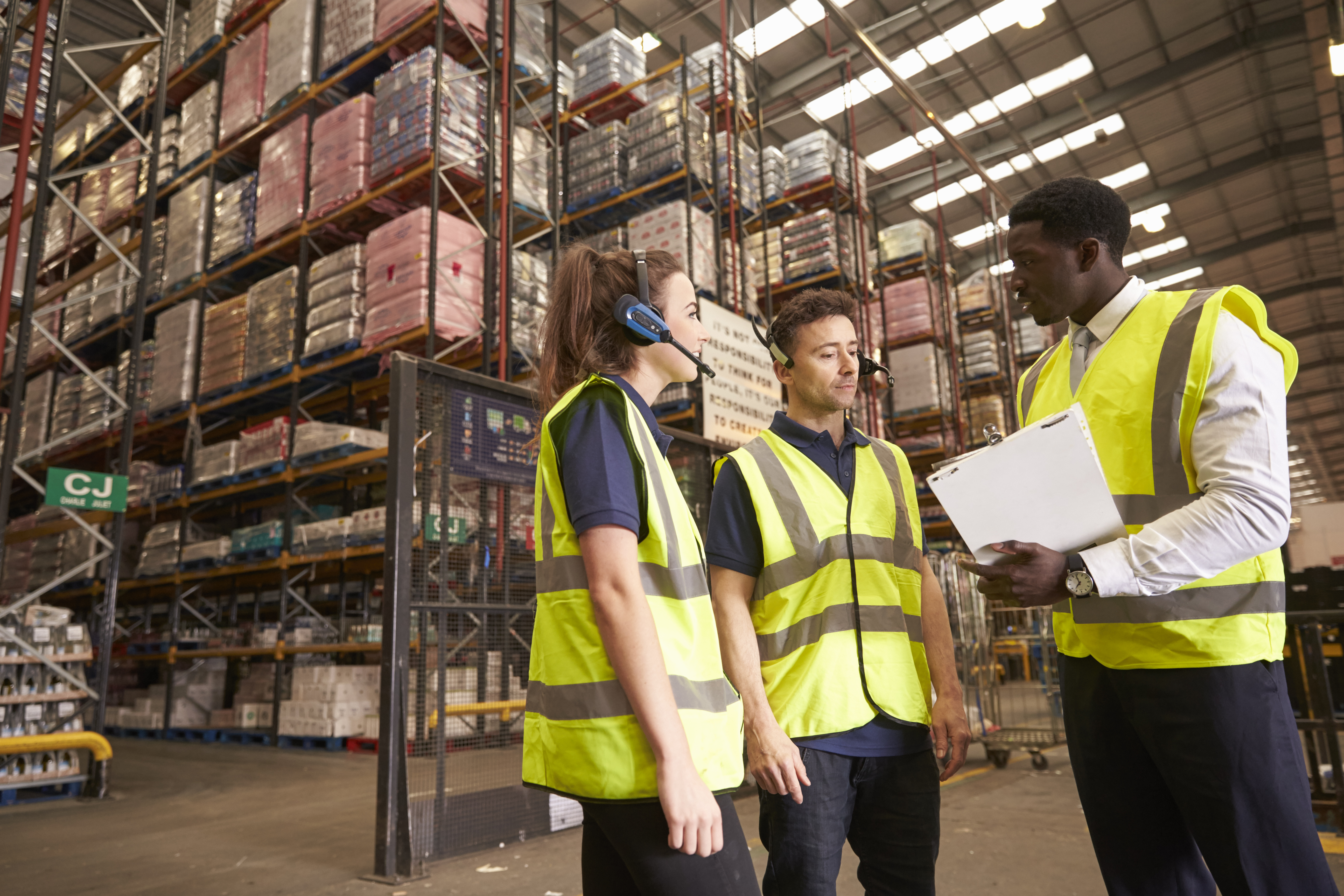 Distribution warehouse manager in discussion with colleagues