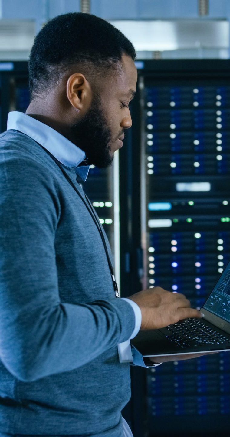 Black Data Center IT Technician Walking Through Server Rack Corr