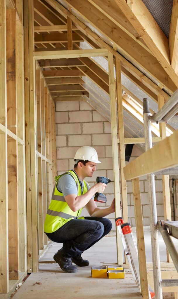 Construction Worker Using Drill On House Build